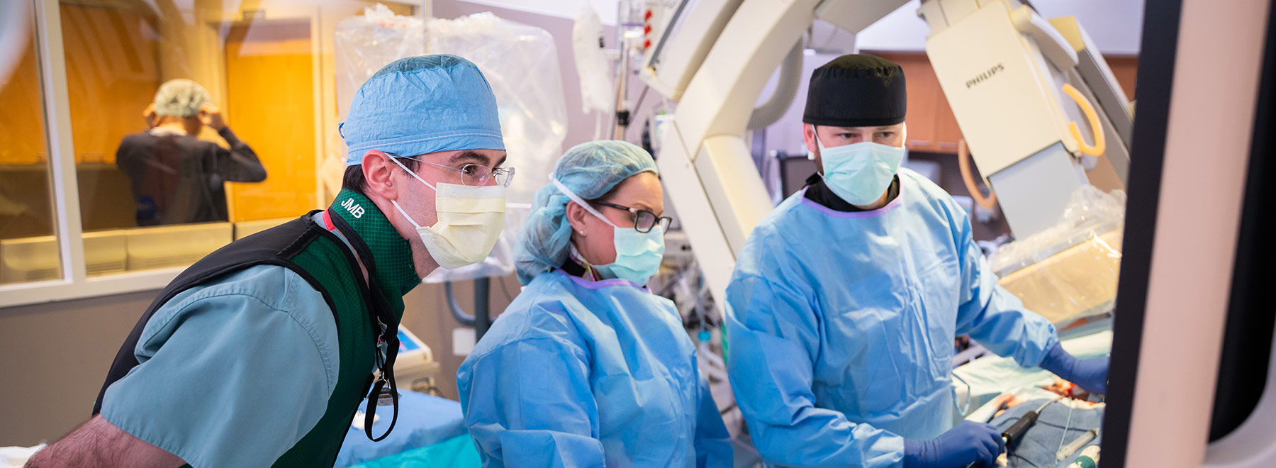 Three gowned people in procedure room